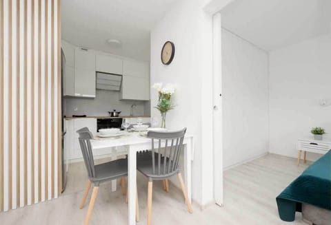 A dining area with a small round table and chairs, seamlessly connected to the kitchen, maximizing space efficiency.

