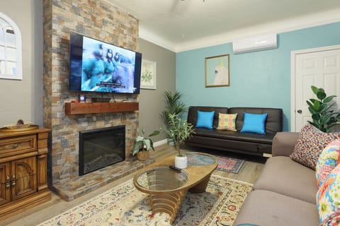 This cozy living space features a decorative fireplace, TV, AC and heating