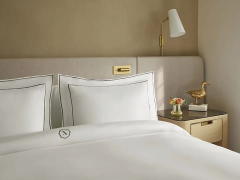 Drift off comfortably with serene decor and a quiet bedside glow.