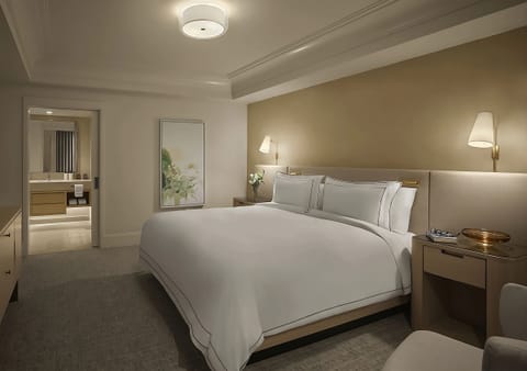 Sink into crisp linens in a calm, elegant bedroom.