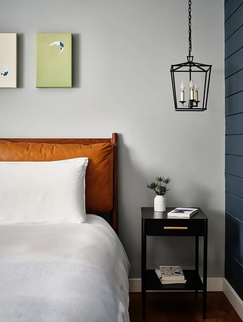 Drift off beside warm lighting and thoughtful bedside touches.