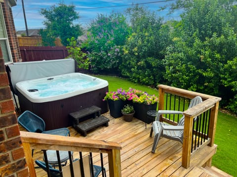Enjoy relaxing in the hot tub surrounded by lush landscaping and deck seating. 