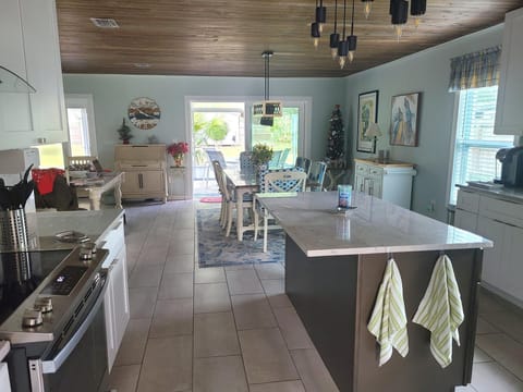 KITCHEN AND DINING ROOM WITH 8 FT. SLIDING HURRICANE DOOR TO SCREENED-IN LANAI