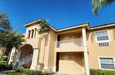 Exterior view of the building with tropical landscaping, covered entryways, and a bright Florida-style design.