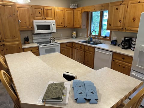 A full kitchen features a range, microwave, dishwasher, and large refrigerator.