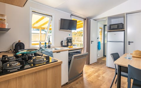 Modern and fully-equipped kitchen with a dining setup for two — ideal for intimate meals or morning coffee.