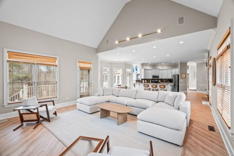 Large, open concept kitchen & family room featuring an 80 inch tv & high vaulted ceilings.