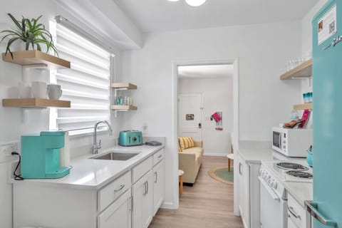 Fresh white kitchen w/ open shelves, ample counter space, and a light, welcoming vibe