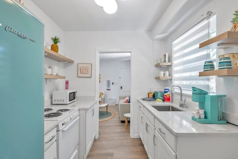 Kitchen view highlighting prep space, storage, & bright coastal-inspired touches.