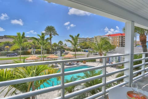 Balcony view overlooking the pool & palms, bringing tropical vibes right to you.