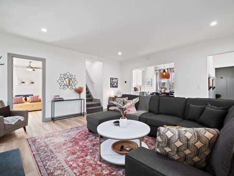 - Living area with sectional sofa and cozy seating decor - View of dining room kitchen and stairs to upper level - Bright layout ideal for family vacations and relaxing