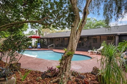 Huge inground pool surrounded by tropical landscaping and courtyards
