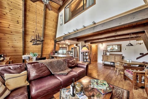 Open concept great room on main / mid level with sectional leather sofa, dining area, nicely appointed kitchen, large flat screen TV, wood burning fireplace and vaulted ceilings / windows.