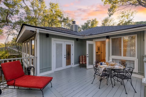 Outdoor deck with lounge space and a dining table.