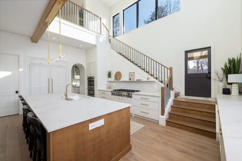 Staircase and kitchen with 23 ft ceilings.