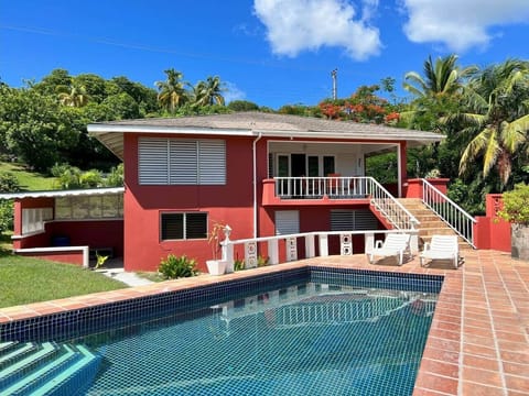 The image features a sparkling swimming pool in the foreground, while a modern house stands in the background, creating a relaxing and luxurious atmosphere.