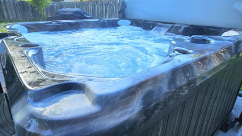 Relax in the hot tub while the kids pay in the back yard
