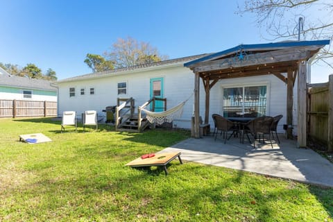 Fenced-in backyard with games, grill, dining areas, and more.