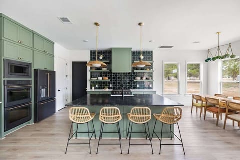 The kitchen features new appliances including a gas stove, double ovens, microwave, refrigerator/freezer, and dishwasher. 