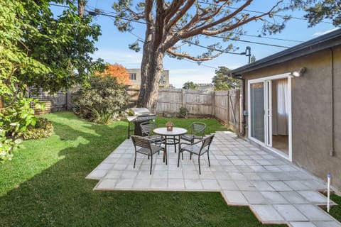 The tiled patio features outdoor seating, making it a perfect spot for BBQs and relaxing in the private yard.