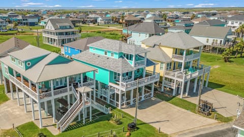 Sandy Toes: An aerial view of our turquoise beach house (center) shows its spacious design, balconies, and prime location just minutes from the beach.