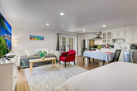 Living room with twin sized couch, Samsung smart TV, coffee table, and chairs.