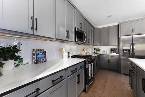 The expansive gourmet kitchen boasts an oversized island, plenty of counter space, and high-end stainless steel appliances.