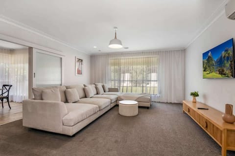 Lounge room with flat screen TV and large couch.