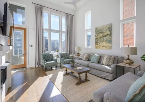 Take a relaxing moment in this spacious living area with high windows capturing the natural light.