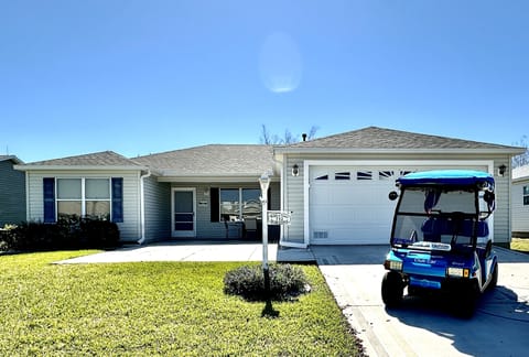 House Front View with Electric 2-Seater Golf Cart for Guest Use