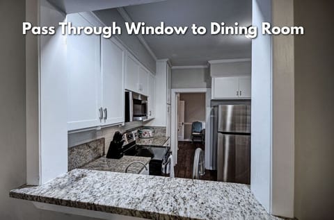 Culinary delights await in our cozy kitchen, complete with a convenient pass-through window for easy dining room service – a perfect blend of charm and utility for your home-cooked meals.