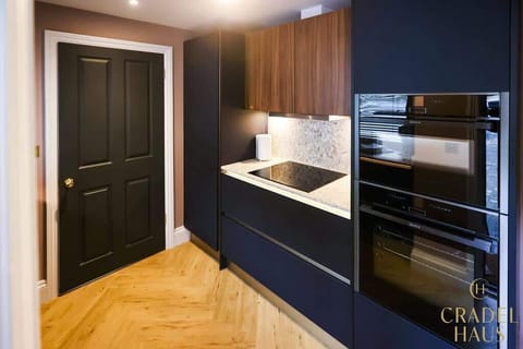 Wainwright's kitchen shines with Neff appliances – microwave, oven, and induction hob. The spacious fridge-freezer ensures ample storage for a delightful family holiday.