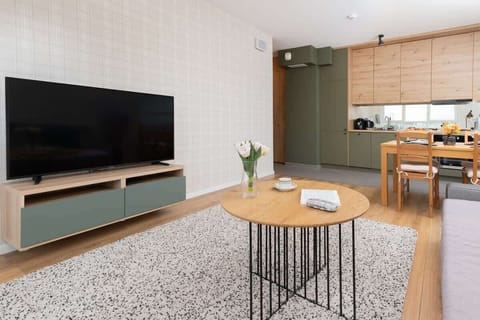 A spacious living and dining area with a neutral color scheme, a large window, and a stylish combination of furniture.