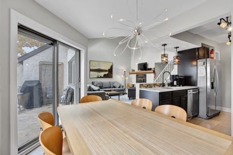 View from dining area to living room with vaulted ceiling and fireplace