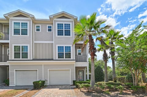 Three-story coastal townhome with private garage, paver driveway, and lush landscaping — your home away from home in Destin!