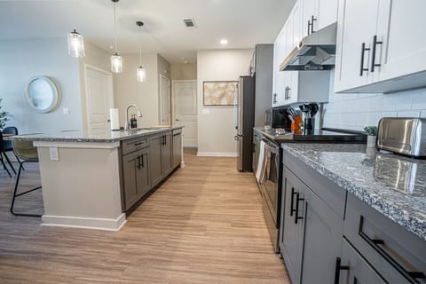 Welcome to our open kitchen! Fully equipped with sleek stainless steel appliances and ample counter space, it`s perfect for cooking and quick meals.