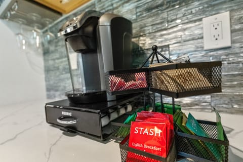 A selection of coffee pods and teas is provided, along with sugar, sugar-alternative, and powdered creamer.