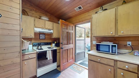 Full kitchen with door that exits to back of cabin/hot tub area.