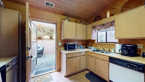 Full kitchen with door that exits to back of cabin/hot tub area.