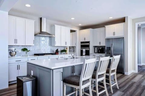 Large fully stocked kitchen with huge island, new stainless steel appliances, and pantry.