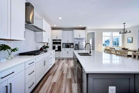 Experience culinary bliss in the generously-sized, fully stocked kitchen featuring a massive island, gleaming stainless steel appliances, and a convenient pantry.