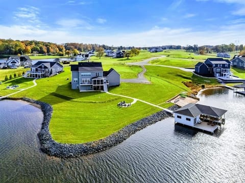 A spacious lakefront home with a large yard, fire pit area, and a private boathouse, offering a perfect retreat for outdoor enjoyment