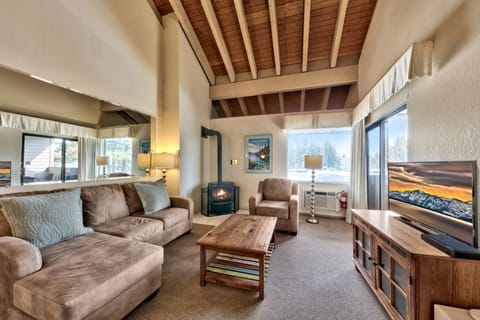 Cozy up by your crackling fireplace in this warm living room, where exposed beams and plush sofas create the perfect mountain retreat.