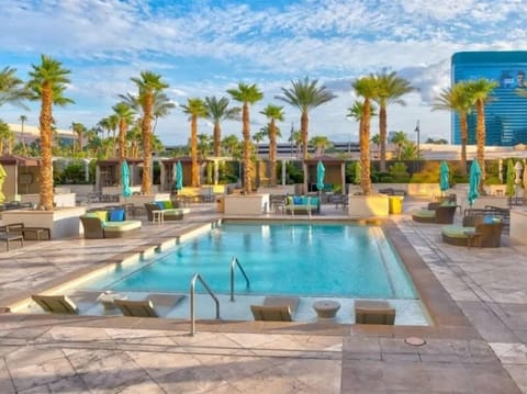 Luxury building amenities: Outdoor pool with ample seating areas and lounge chairs.