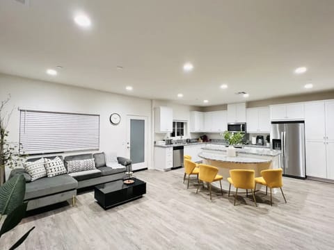Living area and kitchen area along with kitchen island and chairs