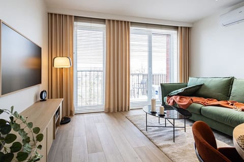Spacious living room with sofa and flat tv and exit to balcony