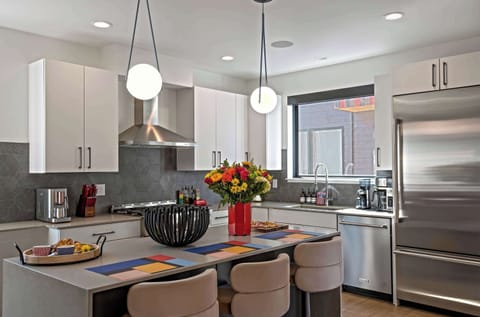 The kitchen island with seating for three serves as the heart of the space, perfect for gathering, casual dining, or enjoying a morning coffee. This central hub offers a blend of functionality and style, making it the perfect spot to connect.