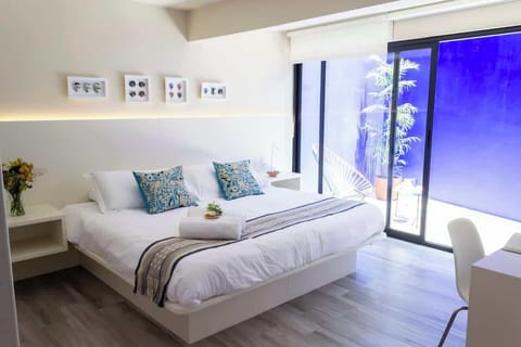 Habitación con cama king size, baño privado y terraza.