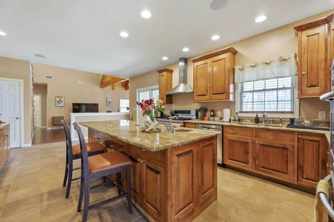 The kitchen features two ovens, and stainless steel hood.