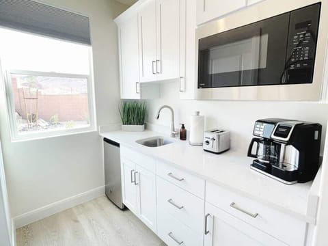 The kitchenette has a refrigerator, microwave, toaster, coffee pot, dishes, and silverware.